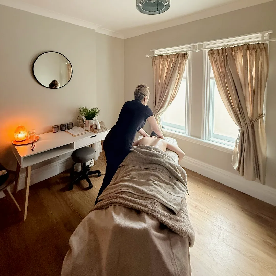 Serene massage therapy session in relaxing room.